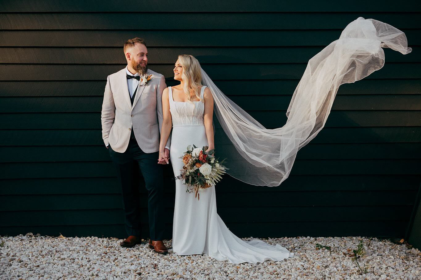 Bride and groom with flowing veil on their wedding day