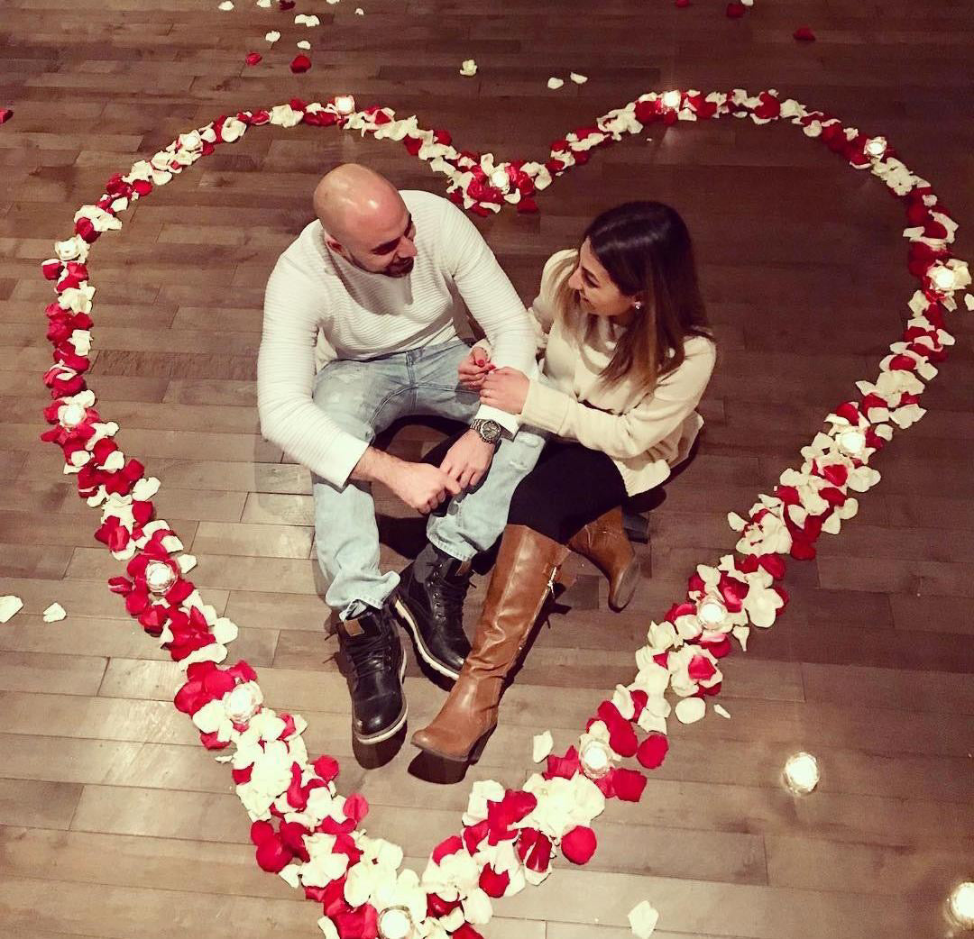 Proposal inside a heart of rose petals at home