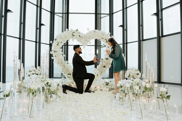 Proposal under a floral heart arch