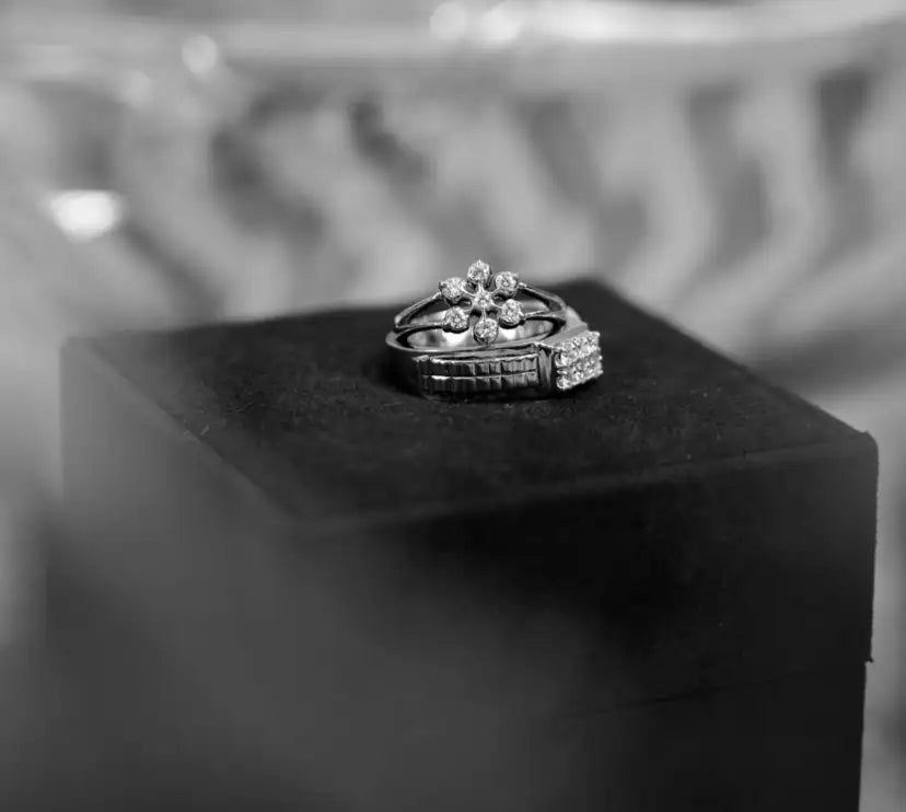 A delicate silver ring adorned with sparkling diamonds arranged in a floral pattern.