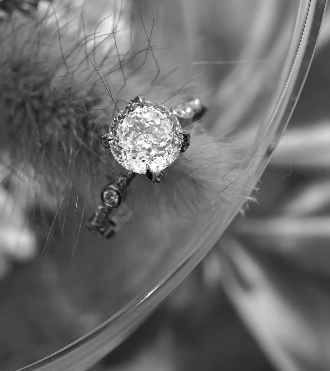 A sparkling diamond engagement ring with a central round-cut stone held by four prongs, accented by smaller diamonds along the band.