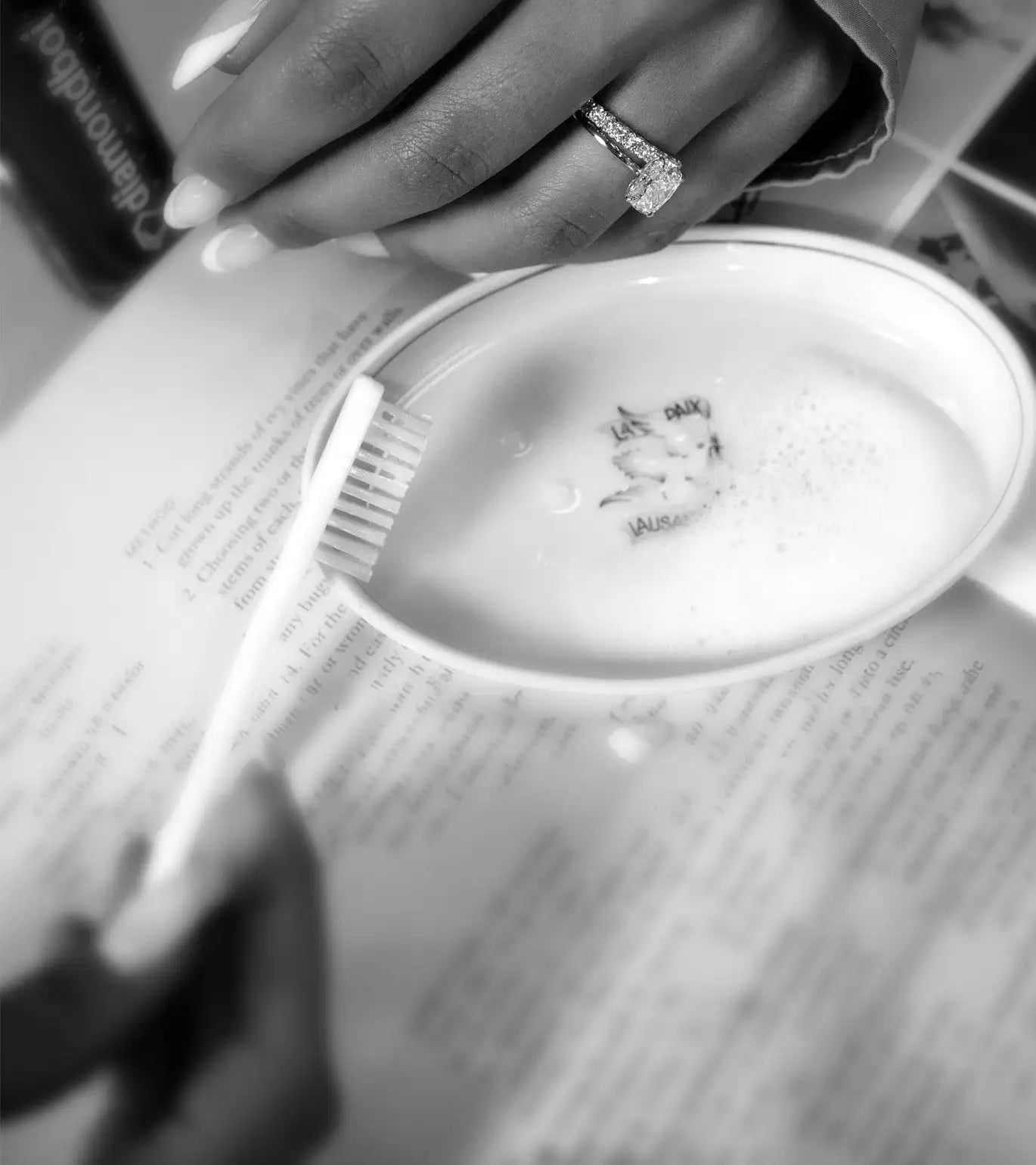 A sparkling diamond engagement ring with a rectangular-cut stone and a textured band, worn on a finger.