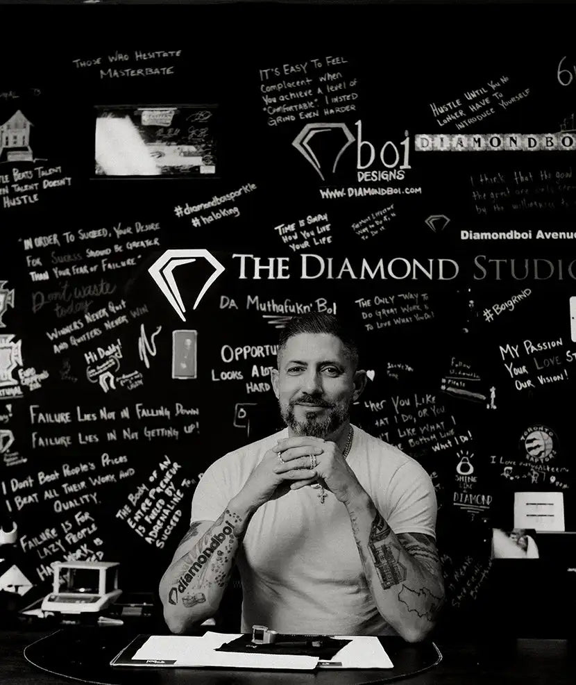 A man with a beard and tattoos, wearing a white t-shirt.