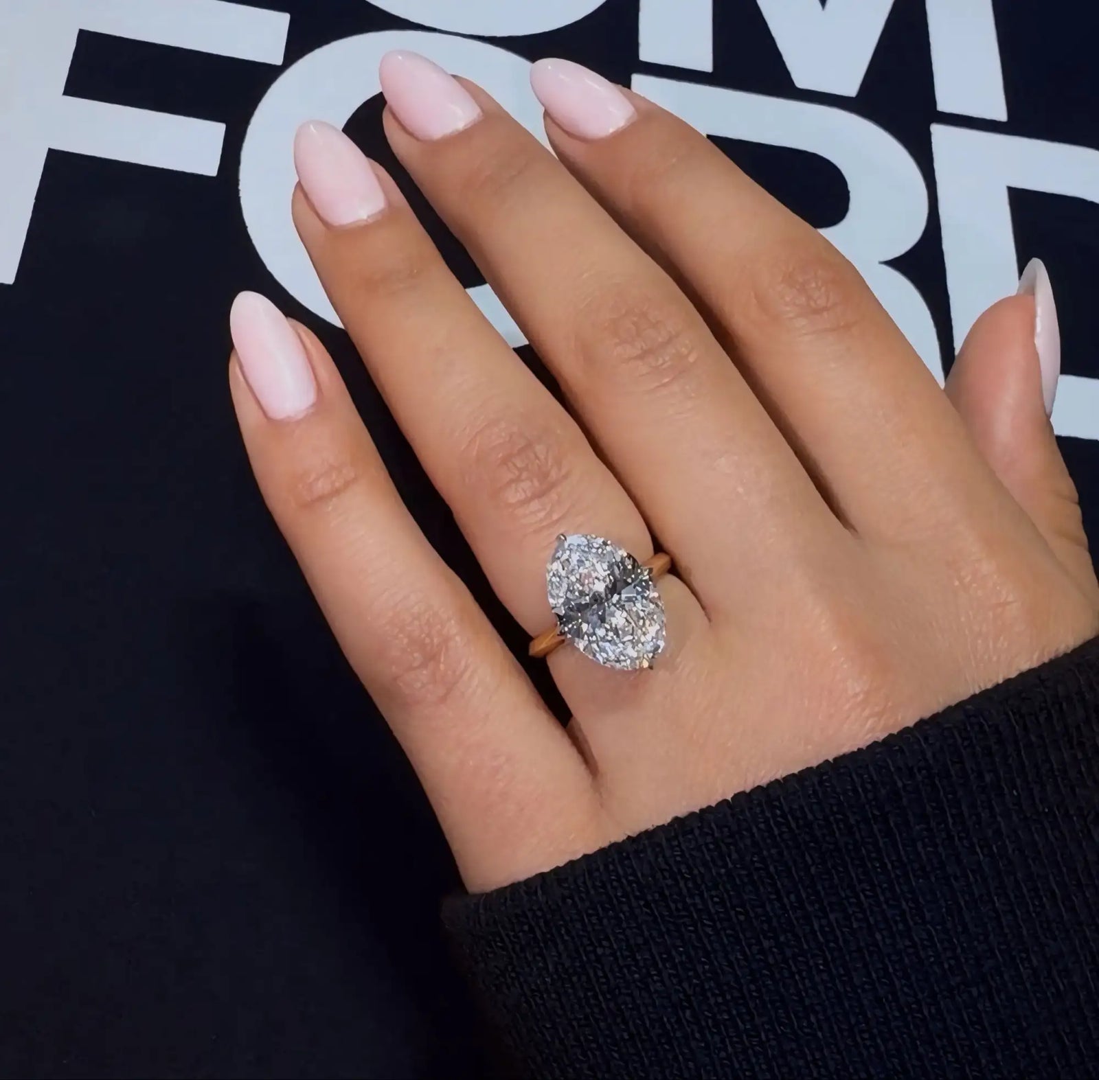 A stunning oval-cut diamond ring with a gold band, showcasing brilliance and elegance.