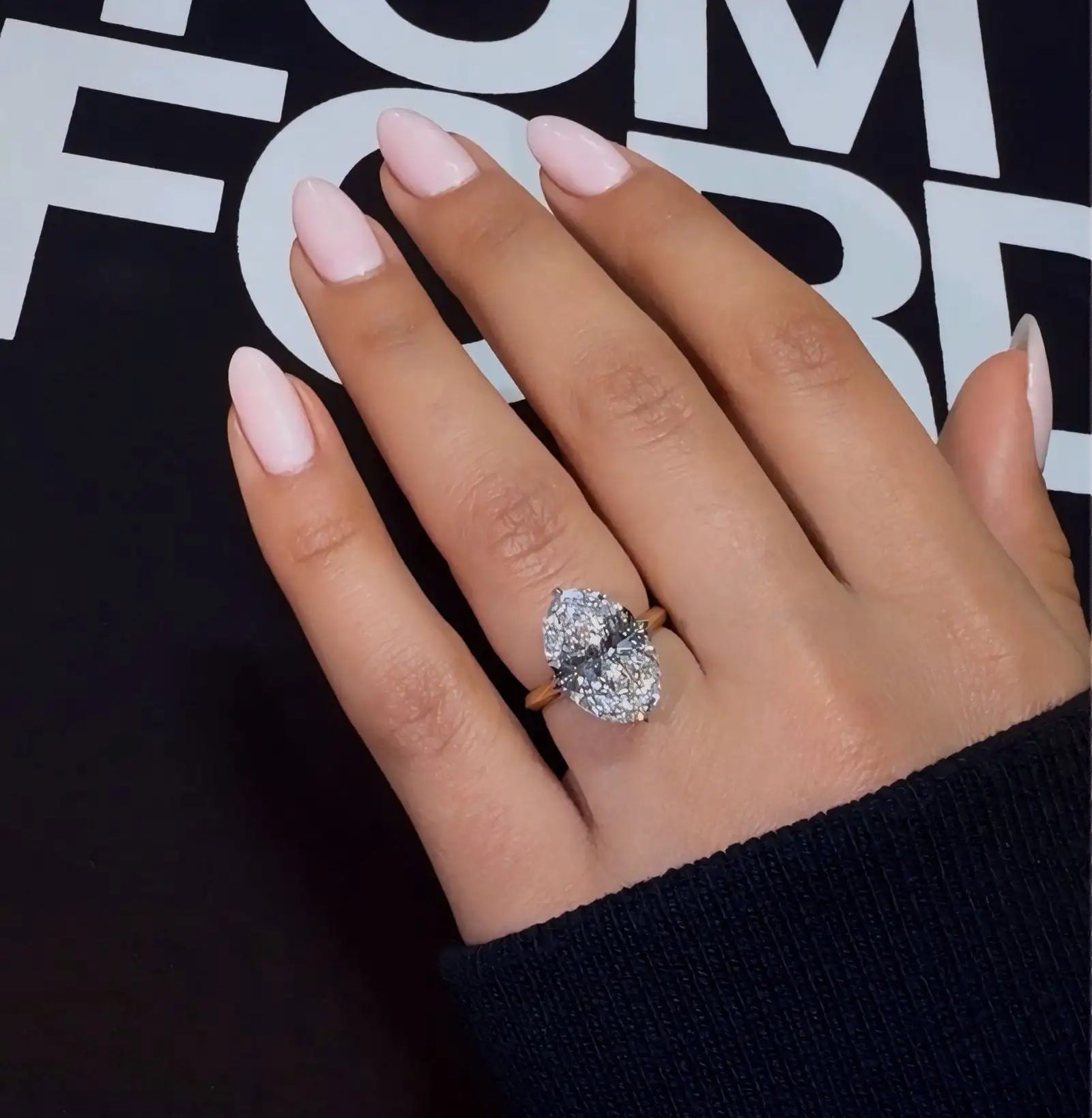 A stunning oval-cut diamond ring with a rose gold band, featuring an elegant and sparkling centerpiece.